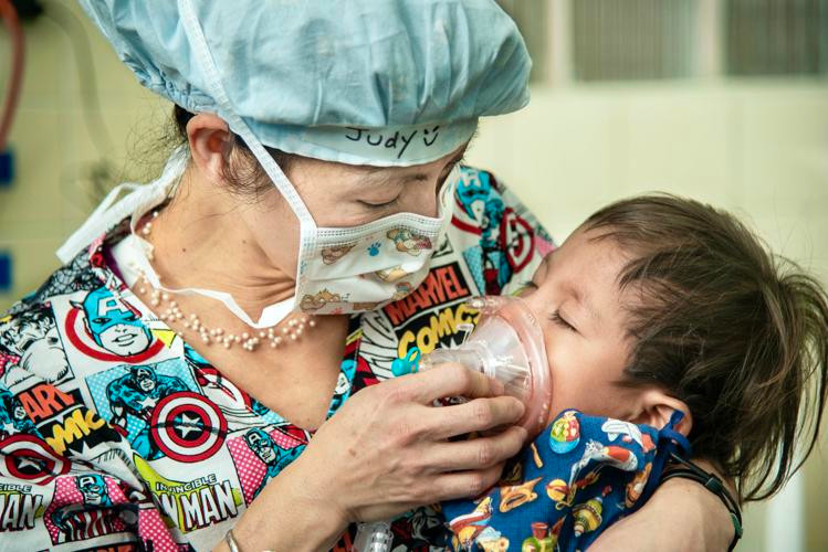 Bác sĩ Judy Nguyễn đang tiến hành gây mê cho một trẻ ở Honduras. Bà là tình nguyện viên thường xuyên của Operation Smile, tổ chức nhân đạo phi lợi nhuận hoạt động trong lĩnh vực chăm sóc sức khỏe cộng đồng, tập trung vào việc thực hiện phẫu thuật miễn phí cho các trẻ em sinh ra bị dị tật hở môi, hàm ếch và các dị tật vùng hàm mặt khác tại các nước đang phát triển. Công việc chính của Judy Nguyễnlà làm bác sĩ gây mê tại một cơ sở thuộc Trung tâm Y tế Winchester, Thành phố Stephens. Ảnh: Operation Smile.