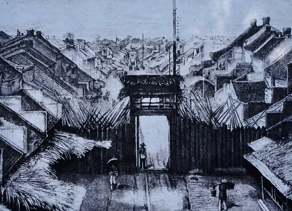 Trung tâm Bảo tồn di sản Thăng Long, Hà Nội phối hợp với Sở Nội vụ Hà Nội, Trung tâm lưu trữ Quốc gia 1 ( Cục Văn thư và Lưu trữ nhà nước) tổ chức trưng bày tài liệu lưu trữ với chủ đề “Hà Nội và những cửa ô”. Sự kiện mở cửa từ ngày 07/10 - 30/10/2024 tại khu di sản Hoàng Thành Thăng Long. Tri thức &amp; Cuộc sống xin giới thiệu tới bạn đọc chùm ảnh tư liệu quý giá đang được trưng bày tại sự kiện này nhân dịp kỷ niệm 70 năm Ngày giải phóng Thủ đô. Trong ảnh là Quang cảnh phố Jean Dupuis xưa (nay là phố Hàng Chiếu), cổng phố bằng gỗ, là một hàng rào đơn giản dựng trên chỗ đất cao để canh gác.