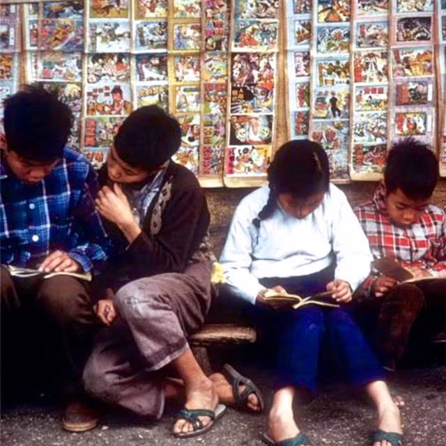 Những cô bé, cậu bé người Hồng Kông đang chăm chú đọc sách tại tiệm sách ven đường năm 1961. Ảnh: sina.com.cn. 