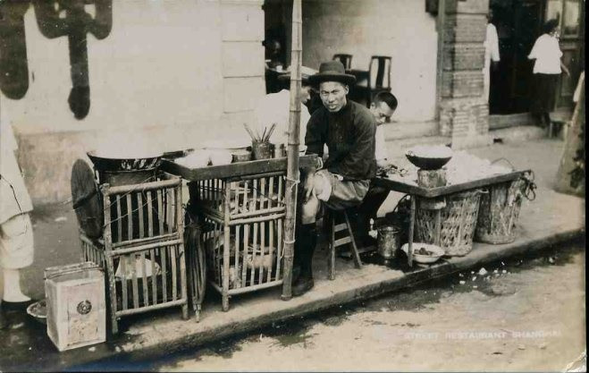 Người đàn ông Trung Quốc bên gánh hàng ăn ven đường. Ảnh: sina.com.cn.