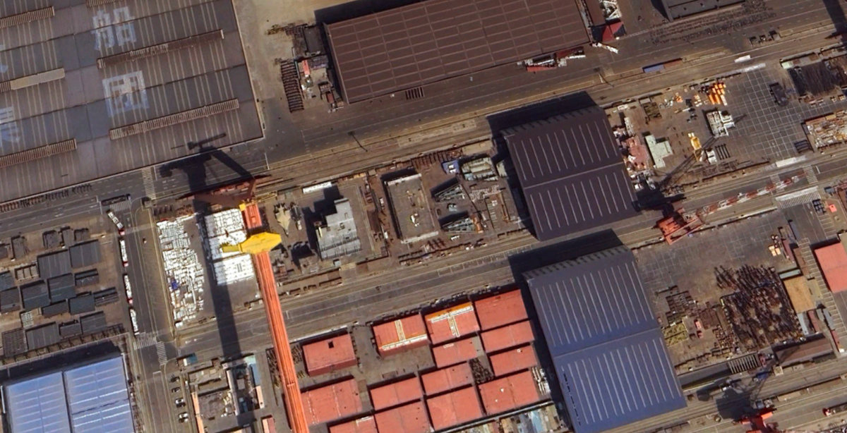 Trên thực tế, tàu sân bay Type 004 mới có thể đã bắt đầu được thiết kế chế tạo.Vào tháng 2/2025, tờ The War Zone đã đưa tin về việc, có một module giống tàu sân bay đã xuất hiện tại một xưởng đóng tàu ở Đại Liên, nghi là của tàu sân bay Type 004. Type 004 mang thiết kế giống tàu sân bay lớp Ford của Hải quân Mỹ, ít nhất là có hai máy phóng máy bay ở giữa tàu, ngoài hai máy phóng ở mũi tàu sân bay. Ảnh: @Google Earth.