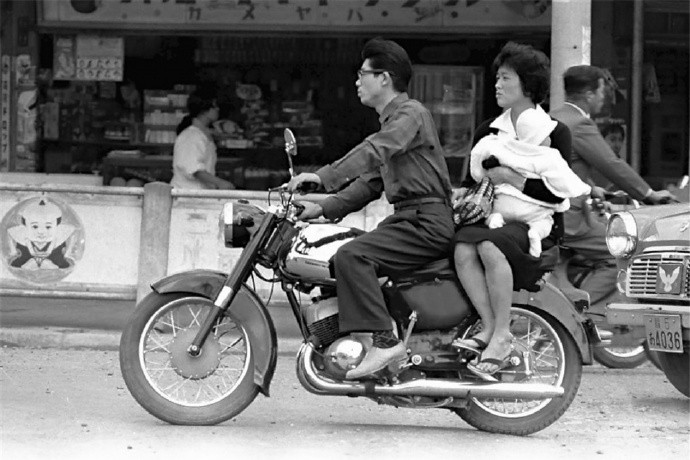 Một gia đình người Nhật gồm bố, mẹ và em bé đèo nhau trên một chiếc xe máy. Ảnh: sina.com.cn.