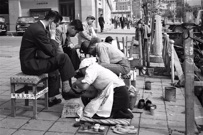 Ảnh những người đánh giày đang đánh giày cho khách trên đường phố Nhật Bản. Ảnh: sina.com.cn.