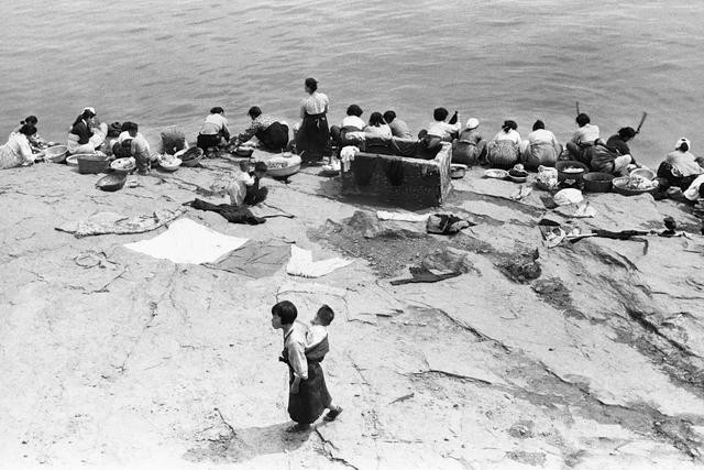 Những người phụ nữ đang giặt quần áo ven sông. Ảnh: sina.com.cn.