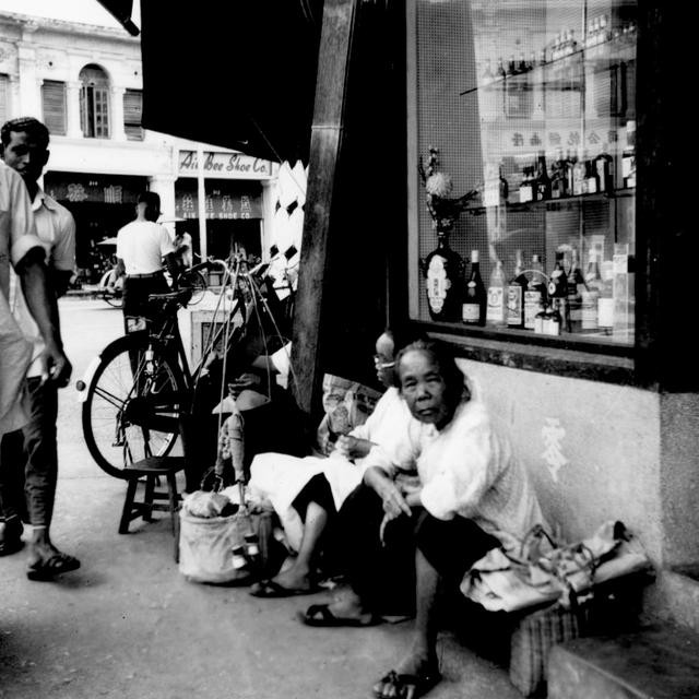 Cụ già người Malaysia ngồi bên vệ đường. Ảnh: sina.com.cn. 