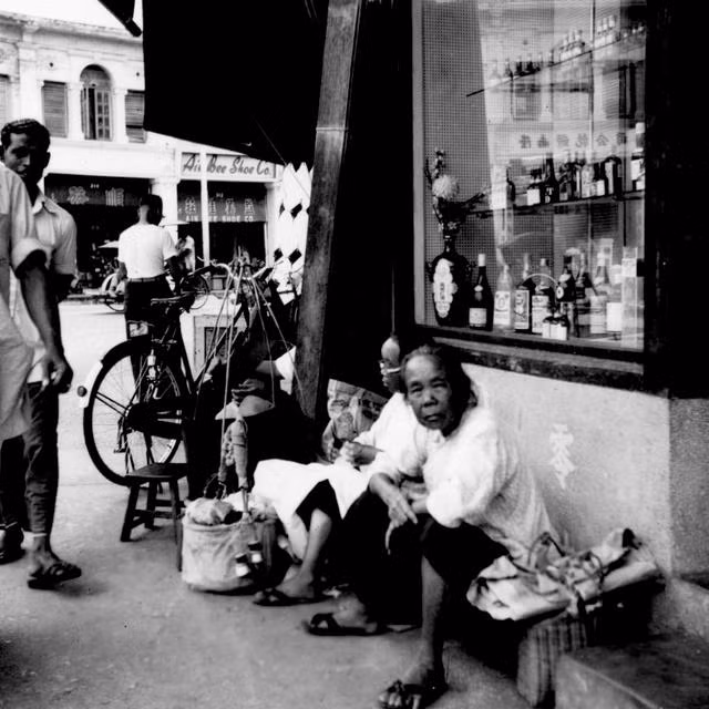 Cụ già người Malaysia ngồi bên vệ đường. Ảnh: sina.com.cn. 