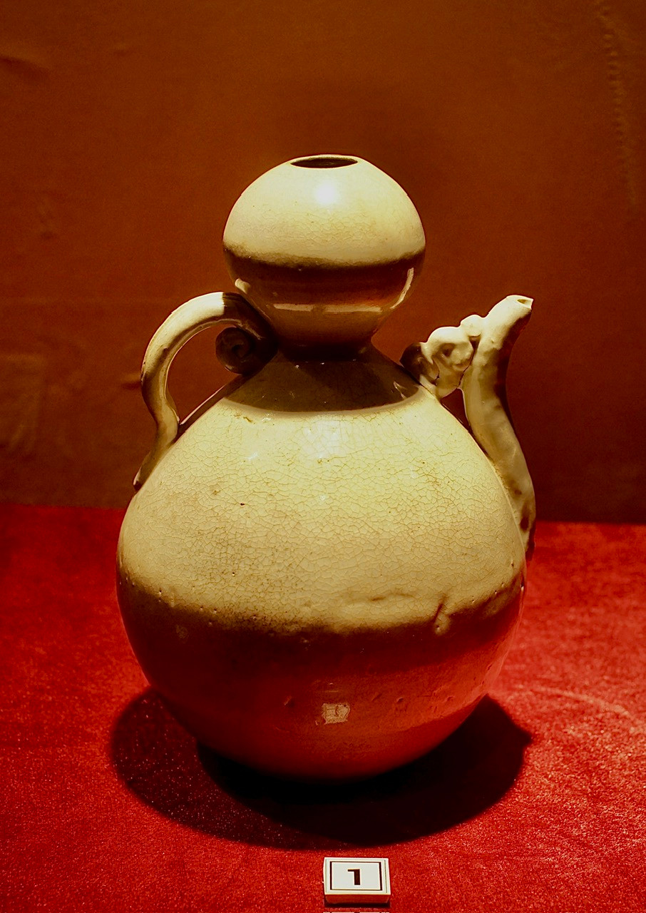 Ấm thắt quả bầu, bằng gốm, men trắng ngà. Niên đại thế kỷ 13-14.