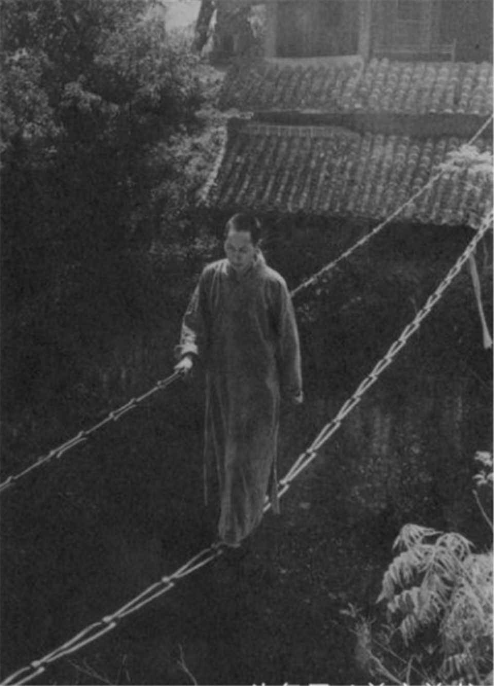 Một vị sư Thiếu Lâm đang đi trên dây qua vực sâu thẳm. Ảnh: sina.com.cn.