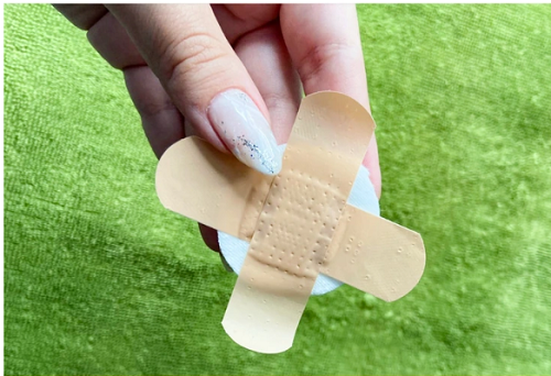 Muốn che nhũ hoa khi không mặc áo ngực, bạn có thể tận dụng hai miếng băng gâu, xếp thành hình chữ X. Muốn tăng khả năng che chắn, chị em có thể gắn một miếng bông hoặc tẩy trang như hình.