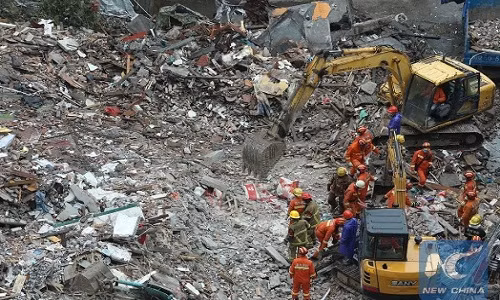 Lực lượng cứu hộ và máy xúc tại hiện trường vụ sập nhà.
