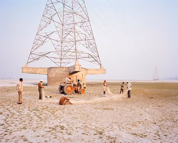Những người đàn ông kiểm tra lưới dưới đáy sông Ganges khô cạn ở Kanpur, Ấn Độ.