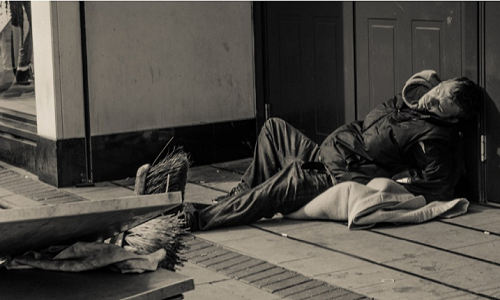 Người đàn ông ngủ ngay tại lối ra vào của một cửa hàng ở Bristol, Anh. Ảnh: Sophie Merlo.