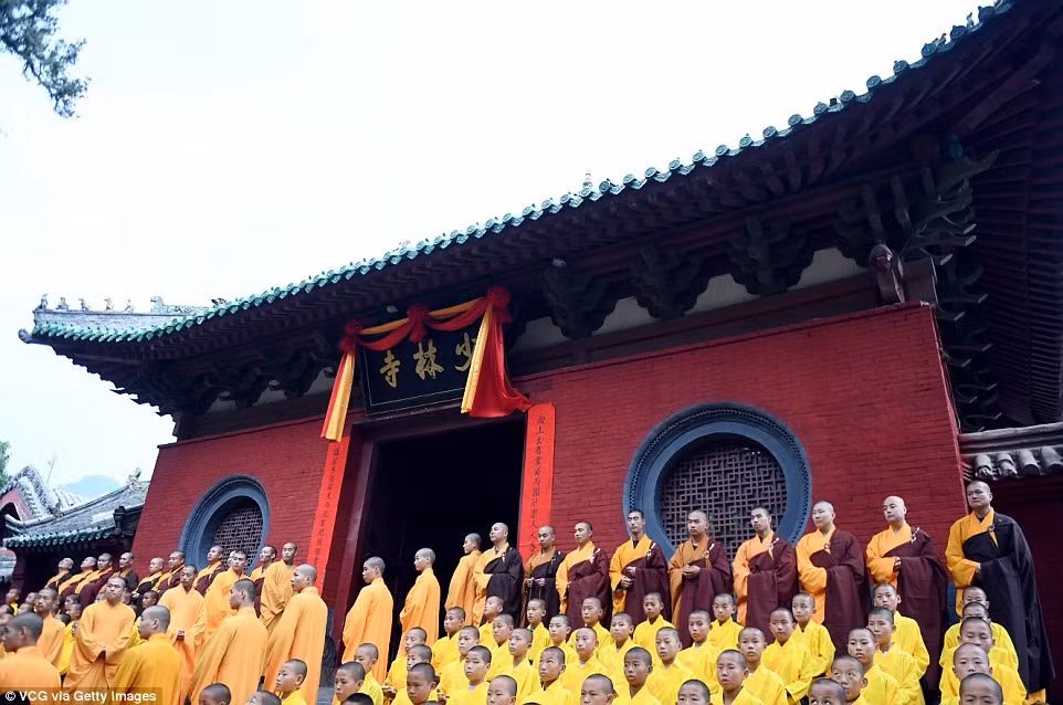 Các vị sư đứng trước chùa Thiếu Lâm Tự, địa danh xuất hiện nhiều trong các bộ phim kiếm hiệp, để theo dõi buổi diễn tập. Ngôi chùa cùng quần thể xung quanh đã được Tổ chức Giáo dục - Khoa học - Văn hóa của Liên Hợp Quốc (UNESCO) công nhận là di dản văn hóa thế giới. Ảnh: Getty.