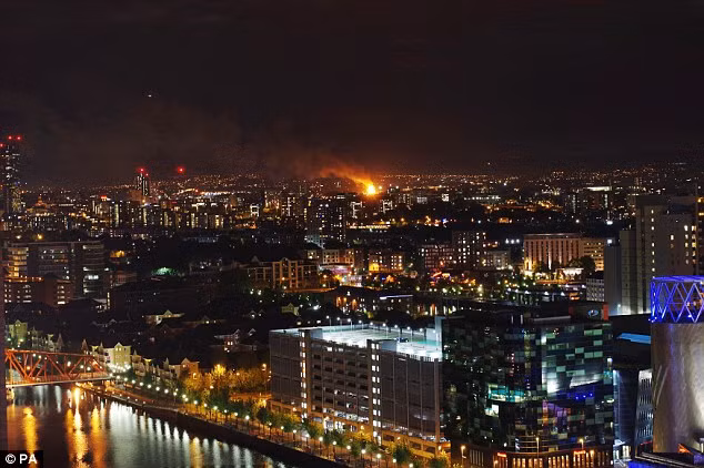 Đám cháy bốc lên từ khu căn hộ ở Manchester nhìn từ xa. Ảnh: PA/Daily Mail.