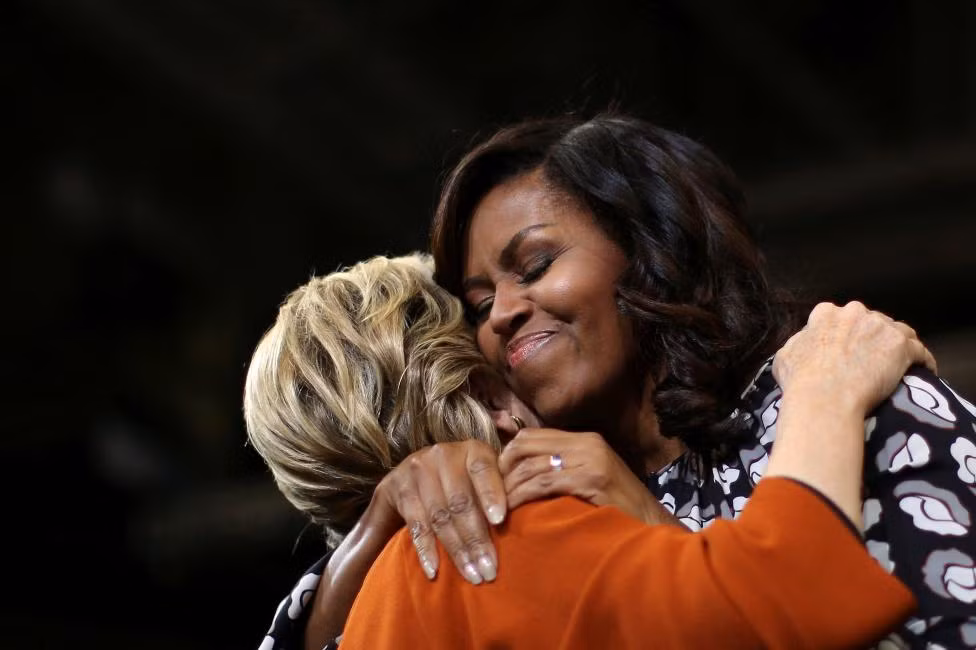  Đệ nhất phu nhân Mỹ Michelle Obama ôm chầm ứng viên tổng thống Đảng Dân chủ Hillary Clinton tại buổi vận động tranh cử ở Winston-Salem, bang Bắc Carolina, hôm 27/10. Được biết, đây là lần đầu tiên Đệ nhất phu nhân Mỹ tham dự chiến dịch vận động của bà Clinton nhằm thu hút cử tri nữ và giới trẻ.