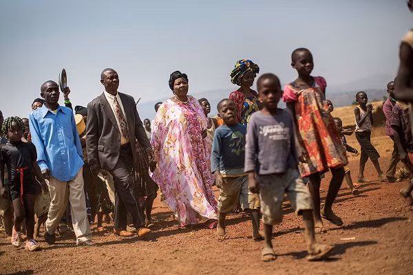 Một cặp đôi người Công-gô đi bộ cùng bạn bè và gia đình tới khu vực sẽ diễn ra lễ cưới tập thể trong trại tị nạn Kavumu.