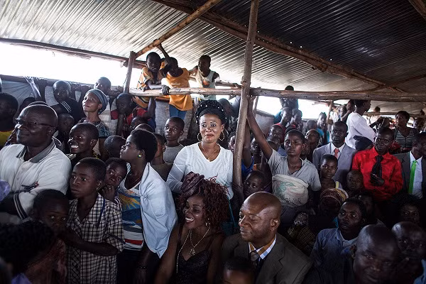 Một người phụ nữ mỉm cười khi trong đám cưới của bạn cô.