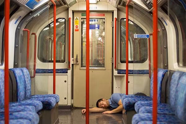 Một người đàn ông ngủ trên tàu điện ngầm London ngày 20/8/2016.