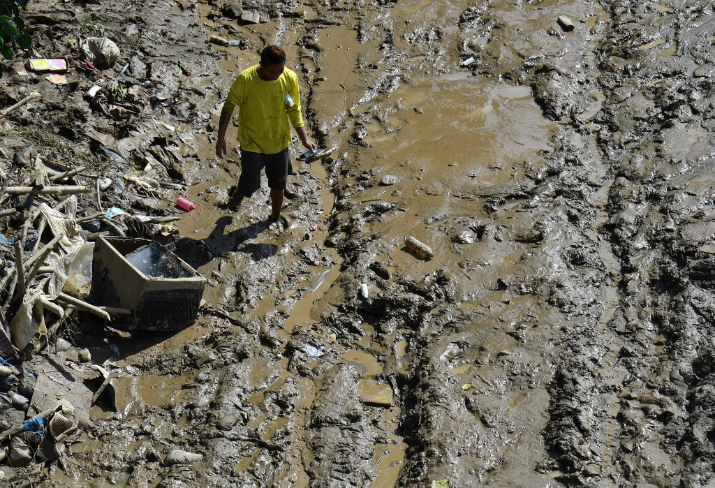 Một cư dân đi trên con đường đầy bùn tại Marikina hôm 13/11. Ảnh: AFP.