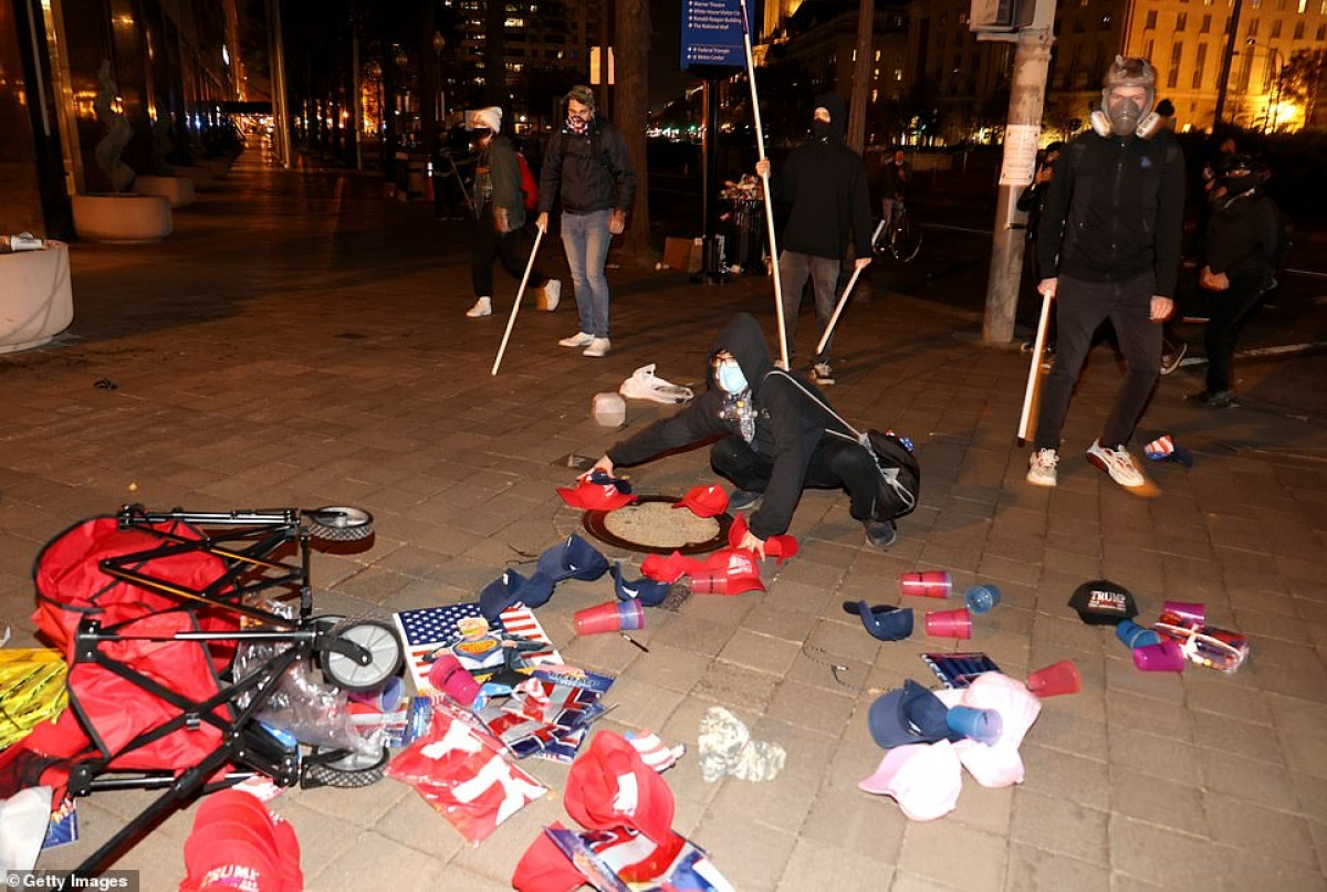 Một người bán hàng rong bị đổ hết hàng của mình do hậu quả xô xát giữa 2 nhóm biểu tình.