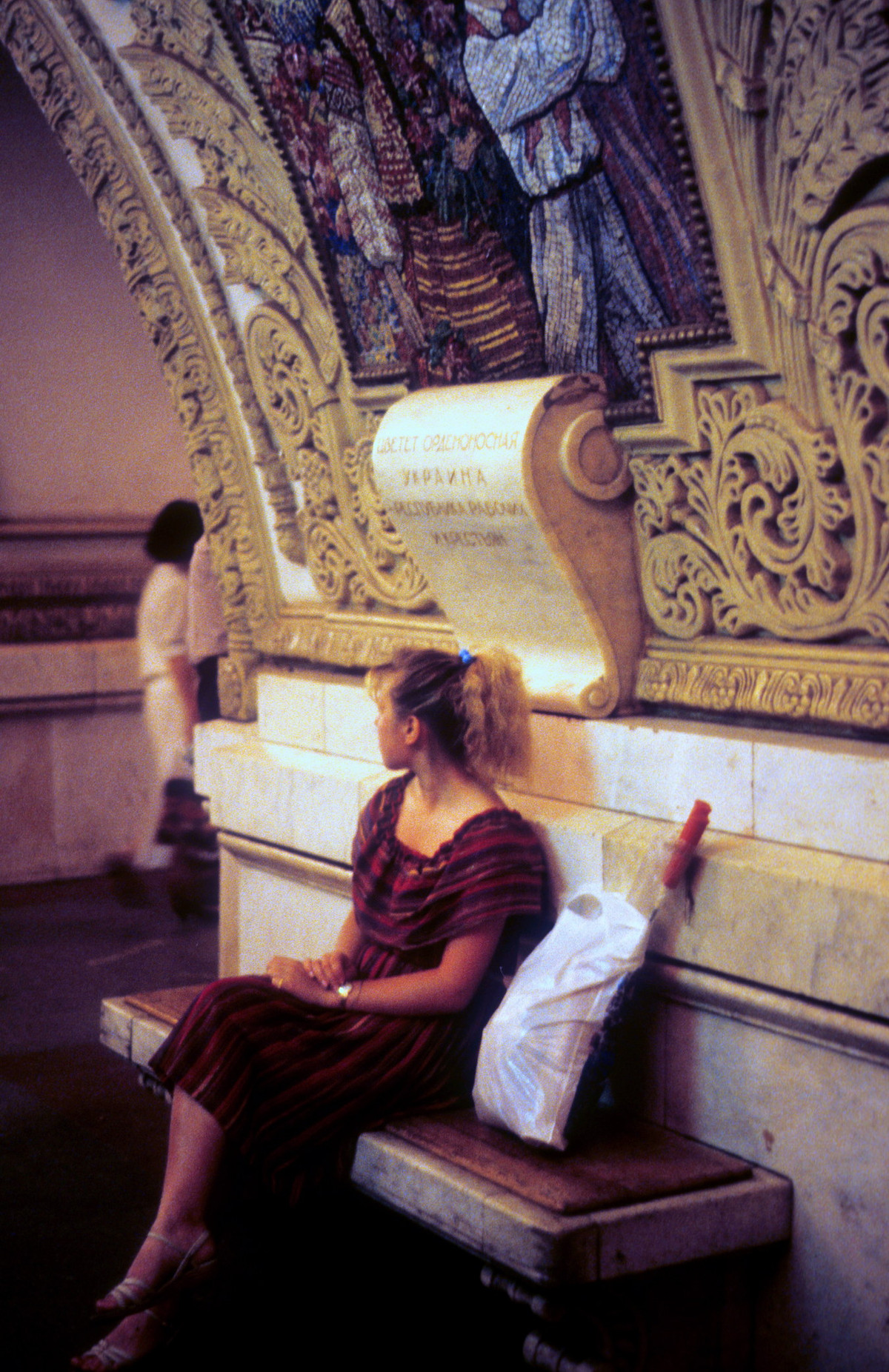 Người đẹp ngồi trên ghế đá tại một ga tàu điện ngầm ở Moscow.