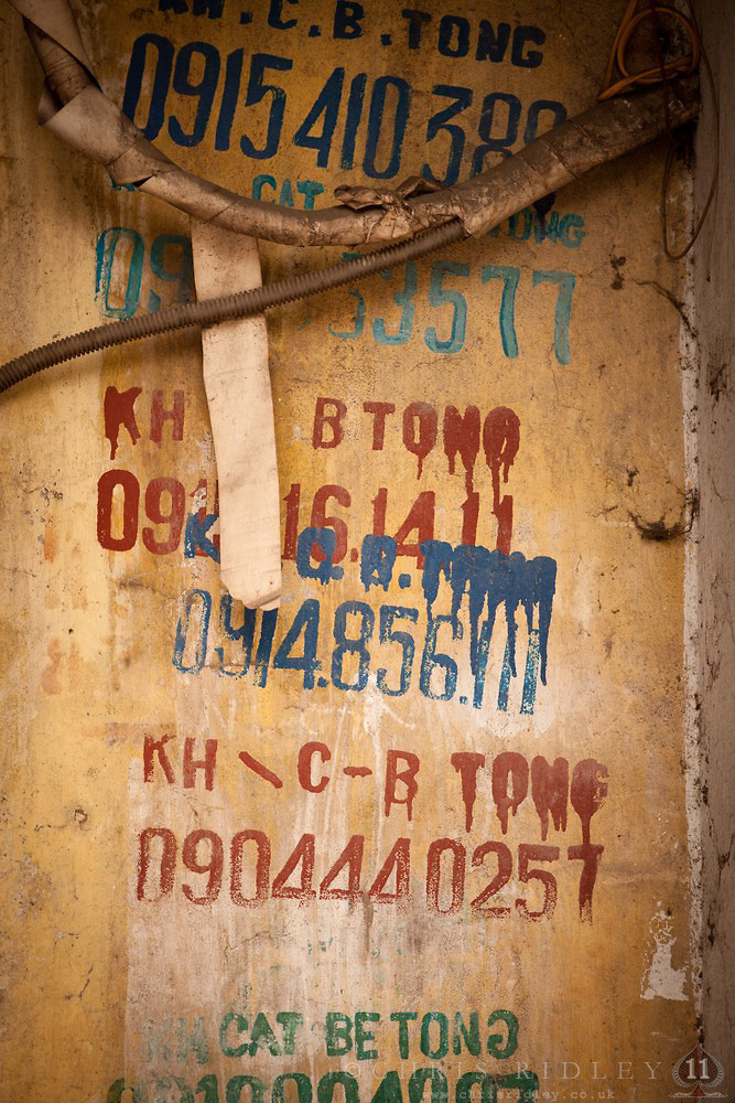 Nhiều bức tường trên các đường phố dày đặc những số điện thoại quảng cáo.