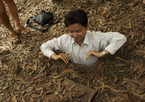 Người hướng dẫn viên (cao 1m55 - bằng chiều cao trung bình của các chiến sĩ du kích ở Củ Chi) làm ví dụ về cách chui vào một đường hầm.