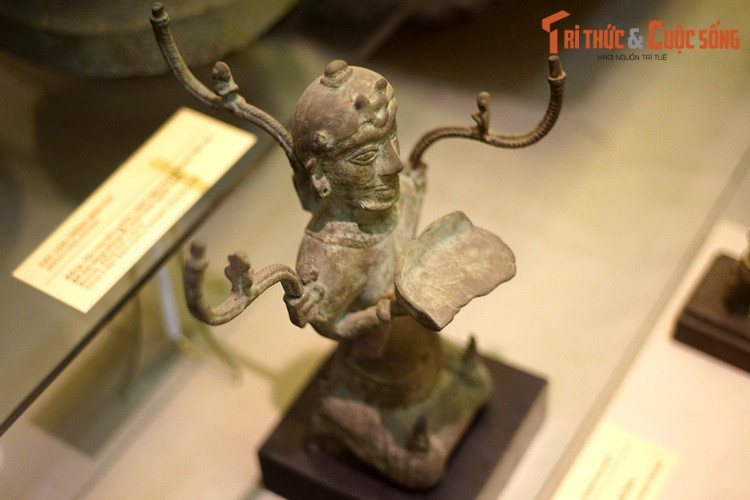 Đèn cao 40 cm, rộng 27 cm, nặng 1,9 kg, mang hình tượng một người đàn ông mình trần, đóng khố, hai tay nâng đĩa đèn trong tư thế quỳ. Trên đầu tượng được gắn vương miện, tóc để chỏm. Có nhiều cách lý giải khác nhau về tạo hình của hiện vật này.