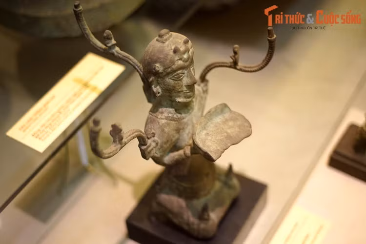 Đèn cao 40 cm, rộng 27 cm, nặng 1,9 kg, mang hình tượng một người đàn ông mình trần, đóng khố, hai tay nâng đĩa đèn trong tư thế quỳ. Trên đầu tượng được gắn vương miện, tóc để chỏm. Có nhiều cách lý giải khác nhau về tạo hình của hiện vật này.