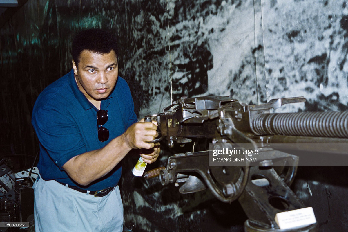 Huyền thoại quyền anh Muhammad Ali bên khẩu súng phòng không 12,7 mm trưng bày ở Bảo tàng Quân đội, Hà Nội ngày 12/5/1994. Lúc đó ông đang có chuyến thăm Việt Nam 5 ngày để xúc tiến việc tìm kiếm hài cốt lính Mỹ mất tích.