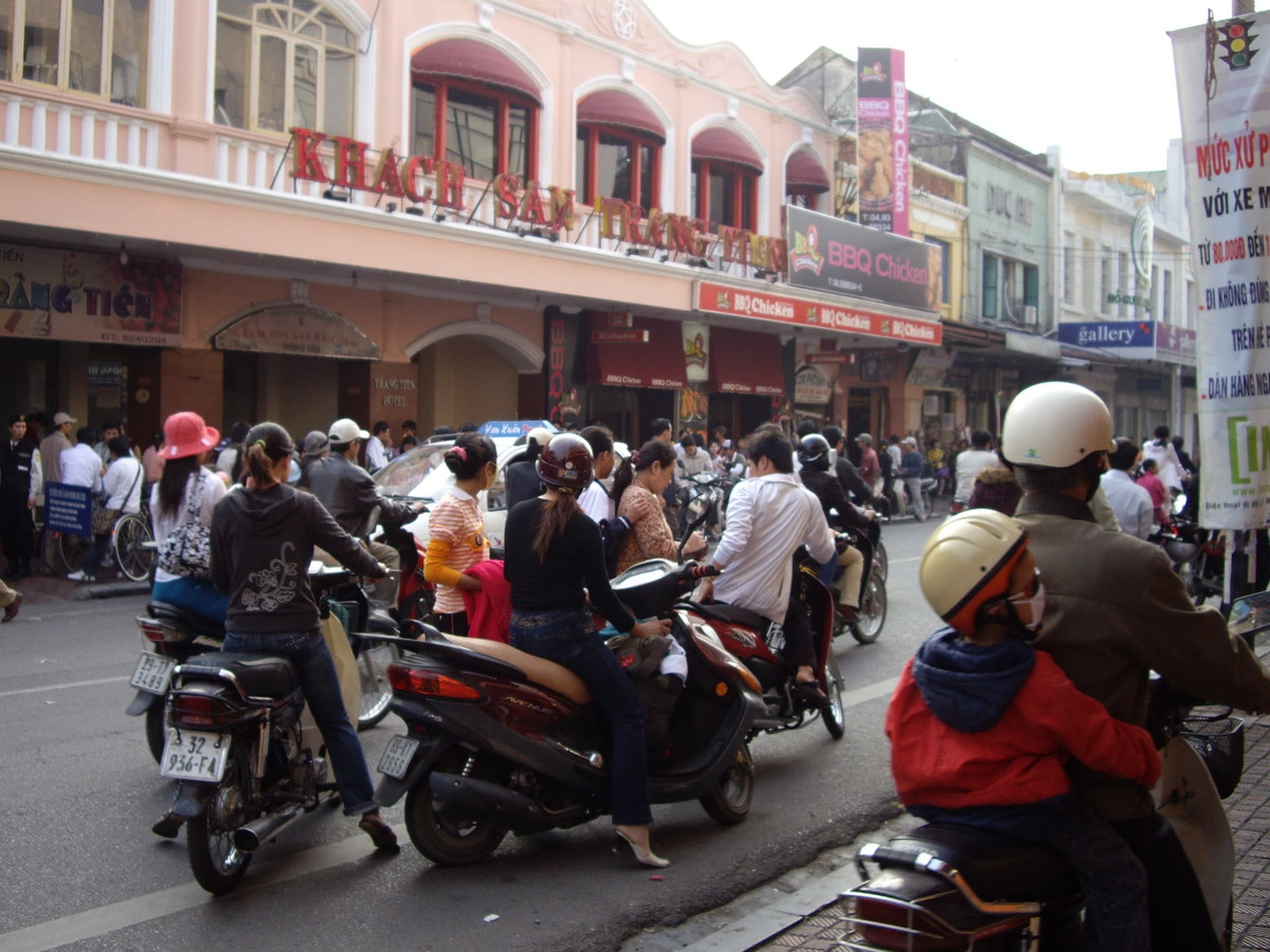 Phố Tràng Tiền, đoạn phía trước cửa hàng kem Tràng Tiền, năm 2008. Cạnh hàng kem huyền thoại có một nhà hàng BBQ Chicken của Hàn Quốc mới mở. Cả hai đều đông khách. Ảnh: Yuichi Kobayashi.