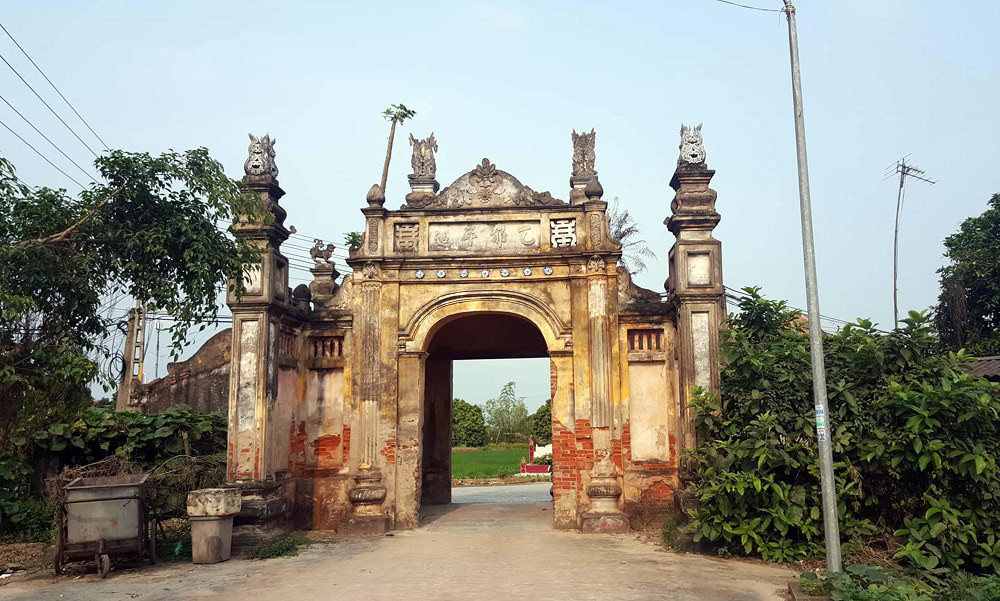 Chạy thẳng con đường hai bên là cánh đồng lúa bát ngát, du khách sẽ gặp cổng làng Nôm.