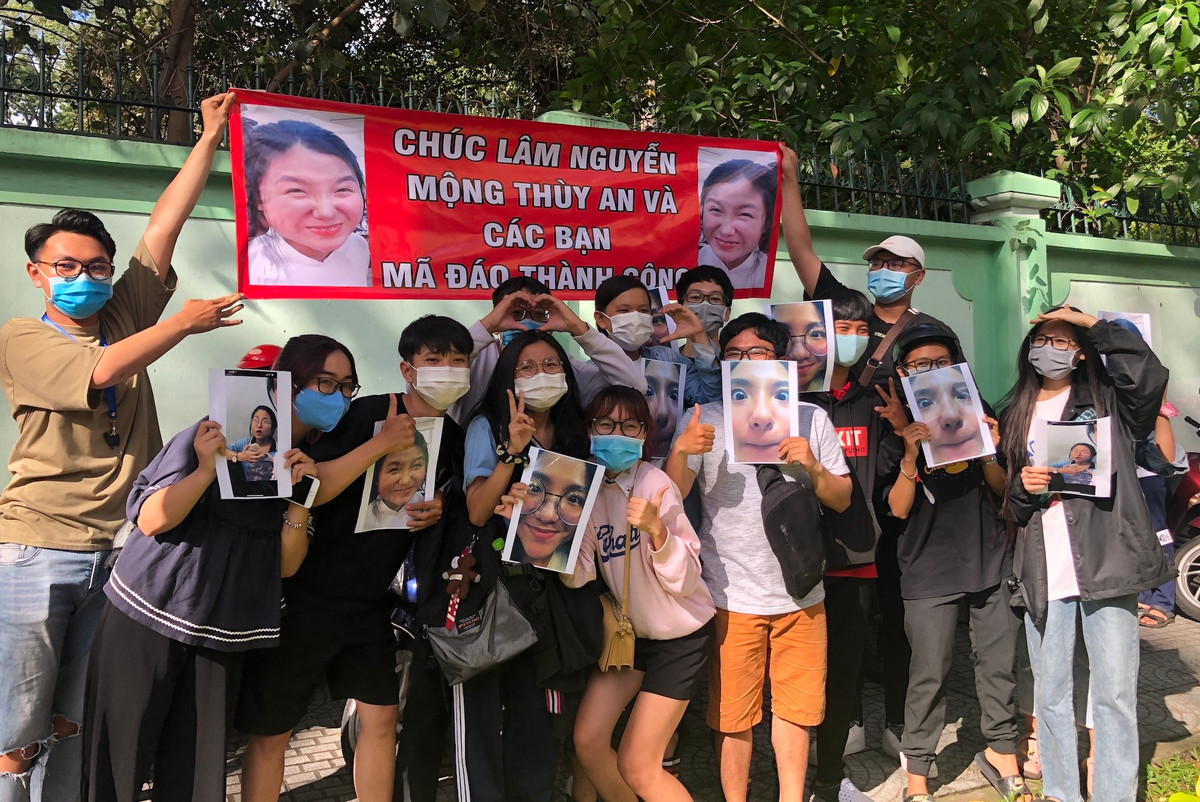 Nhóm bạn trẻ đứng hò reo, căng băng rôn, giơ hình chân dung khi kết thúc buổi thi tốt nghiệp THPT 2020 tại điểm Trường THPT Trưng Vương để động viên tinh thần cho bạn cũng từng làm netizen "cười lăn cười bò".