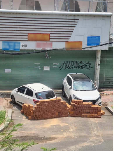 Sau đó, một người đàn ông đã dùng xe vận chuyển và xếp gạch chặn đứng đường đi của 2 phương tiện này.