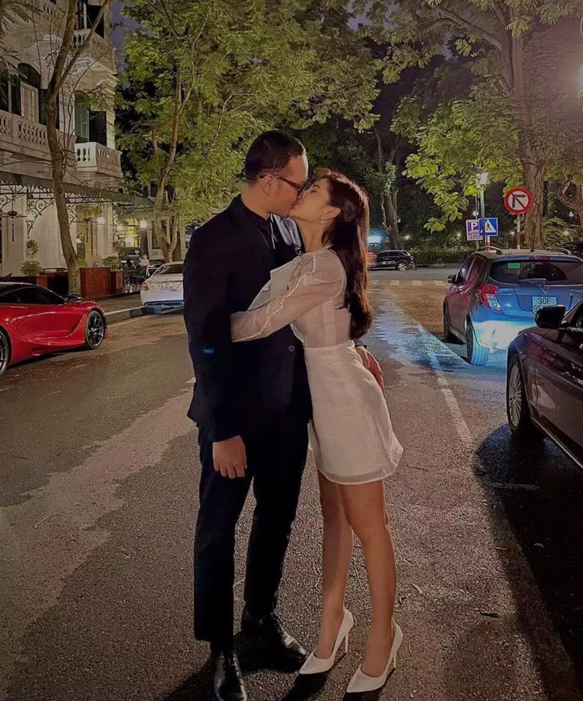 Trong ảnh, nữ MC xinh đẹp mặc một set đồ công sở màu trắng, váy ngắn trên đầu gối. Trong khi anh nhà diện cây vest đen lịch lãm.