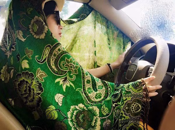 Thậm chí nhiều chị em phụ nữ dù ngồi trong ô tô vẫn quấn trên người kín mít để chống nắng nóng ảnh hưởng đến làn da.