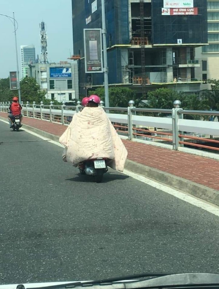 Cách chống nắng bá đạo của hai cô gái ở Đà Nẵng, họ đã lấy chăn dày che kín lên người khi chạy xe trên đường.