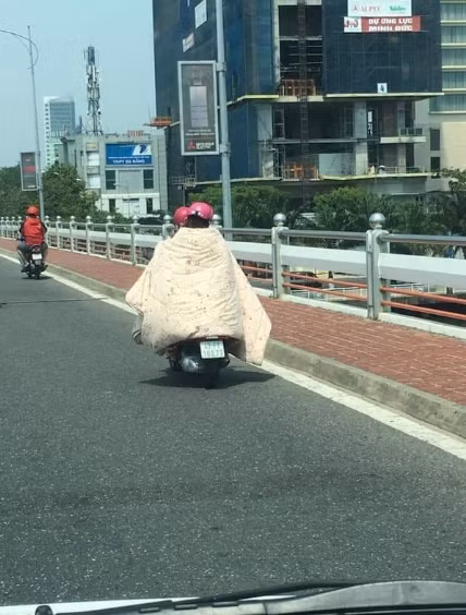 Cách chống nắng bá đạo của hai cô gái ở Đà Nẵng, họ đã lấy chăn dày che kín lên người khi chạy xe trên đường.