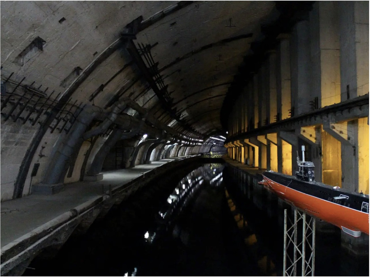 Việc xây dựng căn cứ tàu ngầm bắt đầu vào năm 1957 và hoàn thành vào năm 1961, khi Chiến tranh Lạnh giữa Liên Xô và Mỹ đang lên đỉnh điểm. Để giữ bí mật, địa điểm chiến lược này được gọi là Trạm điện thoại thành phố 825. Đây là cách mà chữ viết tắt "825 CTS" xuất hiện.