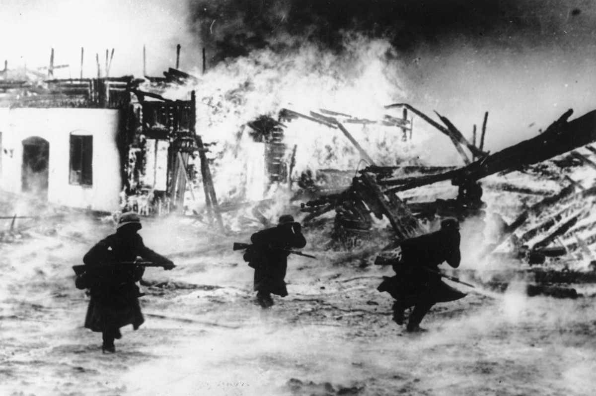 Nhóm lính Mỹ di chuyển qua một ngôi làng ở Na Uy với nhiều ngôi nhà bị thiêu rụi. Ảnh chụp tháng 4/1940.