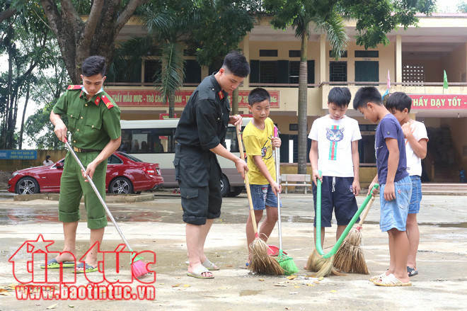 ... cùng các học sinh quét dọn sân trường