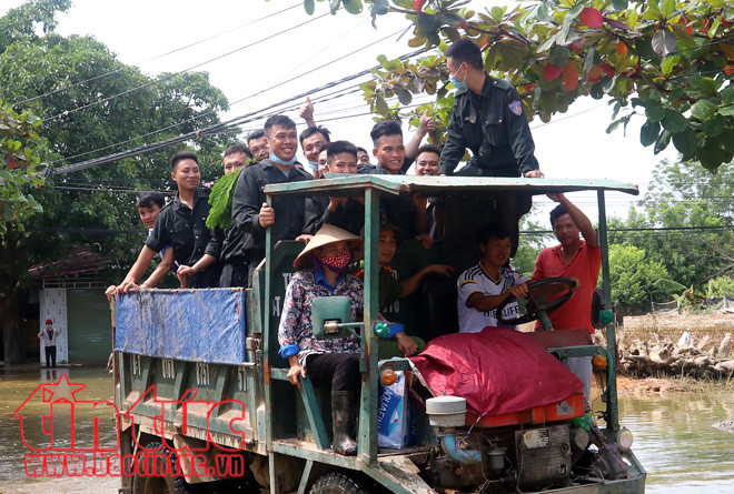 Lực lượng cảnh sát cơ động số 1 cùng bà con xã Nam Phương Tiến đi dọn vệ sinh môi trường trên địa bàn sau ngập lụt.