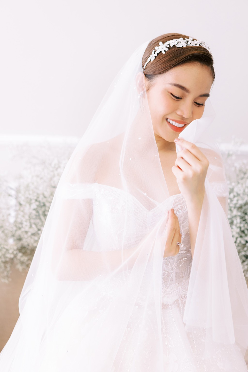 Cô dâu trang điểm nhẹ nhàng, tóc búi cao.