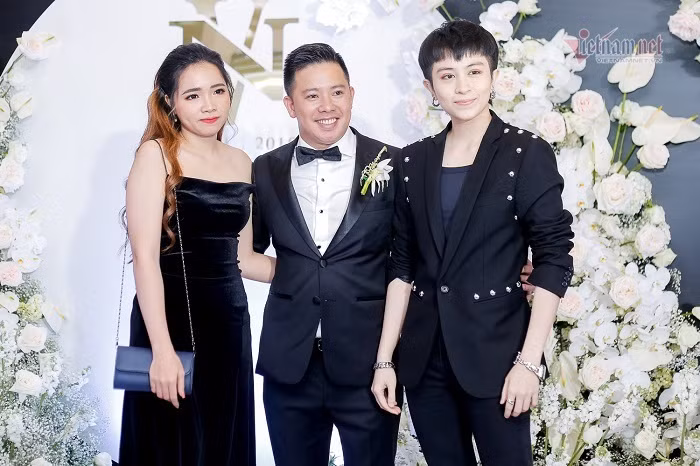 Gil Lê mặc vest đen nam tính, chụp lưu niệm cùng chú rể và diễn viên Hoài An. Sao "Người đẹp Tây Đô" mặc đầm nhung đen, tóc line cam quá trẻ trung ở tuổi 45.