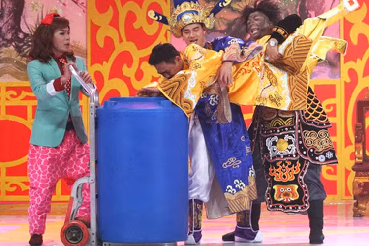 Tham gia Táo quân 2014, Quốc Khánh đóng vai người dân bị Nam Tào dìm đầu vào thùng nước, bị dọa nạt, đánh đập để mô phỏng lại vụ bảo mẫu bạo hành trẻ em. Ảnh: VTV