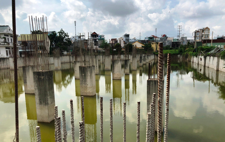 Đi sâu vào phía sau dự án I-Home, công trình ngổn ngang sắt, bêtông, hố sâu ngập nước mưa do quá trình thi công bị bỏ dở.