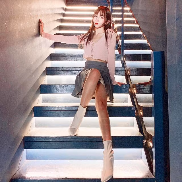 Cũng sử dụng váy xếp ly nhưng Ti Ti mix với crop-top dài tay và đôi boots mũi nhọn màu trắng. Để thu hút hơn, cô nàng chọn trên crop-rop mỏng nhẹ và xẻ sâu.