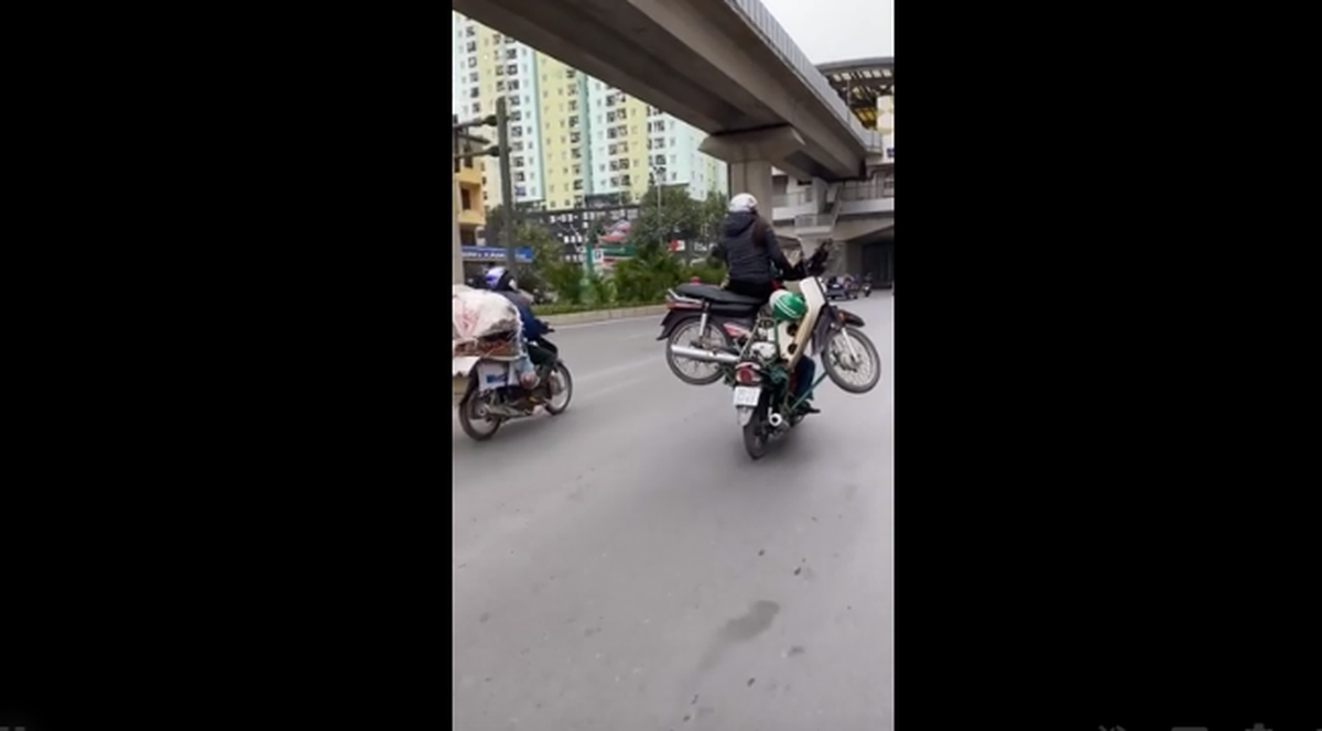 Một nam tài xế xe máy đã chở theo phía sau một chiếc xe máy và 1 người ngồi trên xe này.