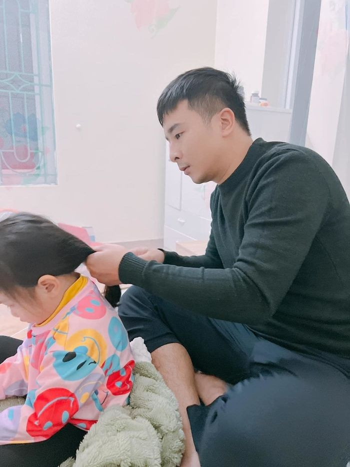 Đầu tiên ông bố rất khéo léo khi cột tóc gọn gàng lại cho con, nhắm thật chuẩn để cho màn cắt tóc.