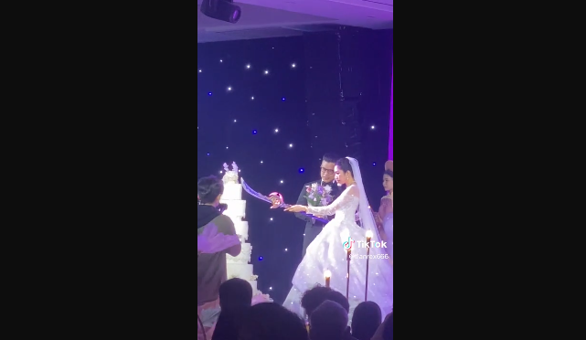 Trong ảnh cô dâu dường như xúc động không nói nên lời còn chú rể thì nở 1 nụ cười tỏ rõ sự thỏa mãn vì mình đã có màn cắt bánh cưới "có 1-0-2" này.